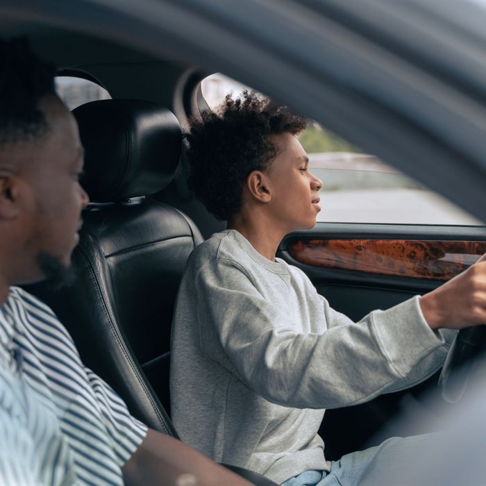 A teen driver at the wheel with a supervising adult beside them